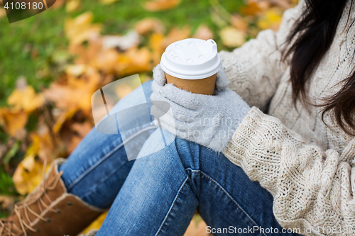 Image of close up of woman drinking coffee in autumn park