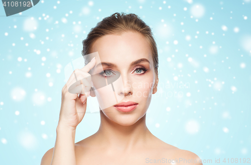 Image of beautiful woman showing her forehead over snow