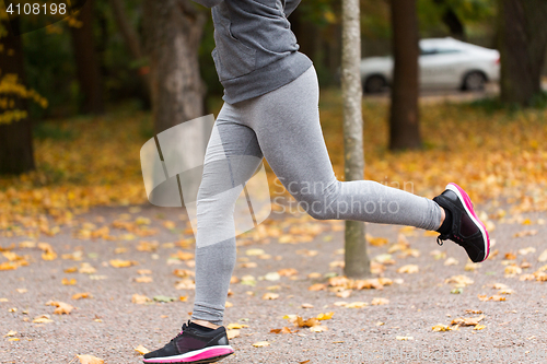 Image of close up of young woman running in autumn park