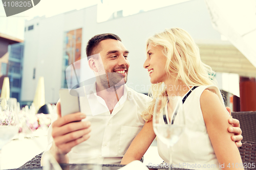 Image of couple taking selfie with smatphone at restaurant