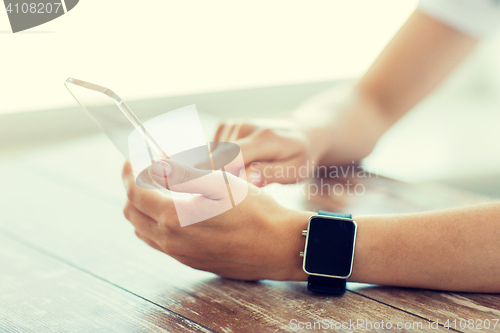 Image of close up of hands with smart phone and watch