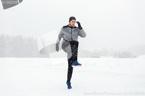 Image of man exercising and warmig up in winter outdoors