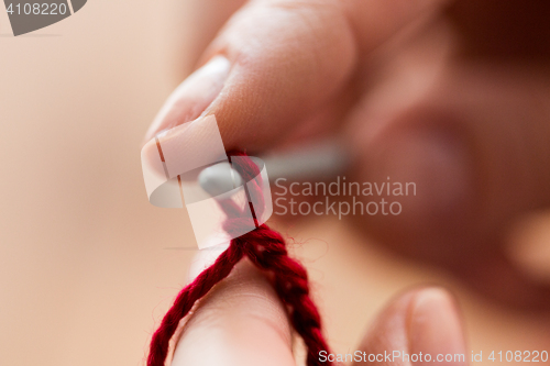 Image of close up of hands knitting with crochet hook