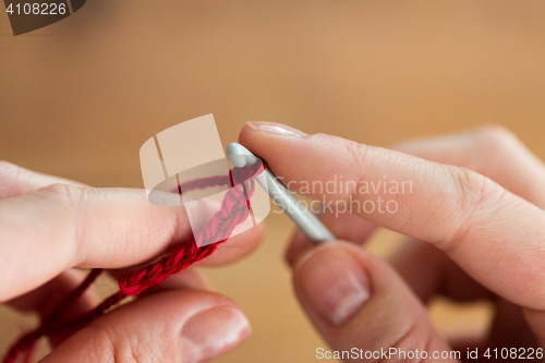 Image of close up of hands knitting with crochet hook