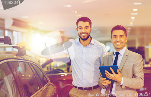 Image of happy man with car dealer in auto show or salon