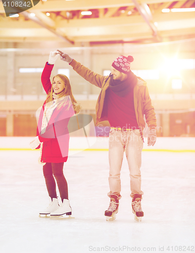 Image of happy couple holding hands on skating rink