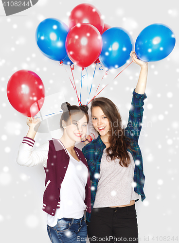 Image of happy teenage girls with helium balloons over snow