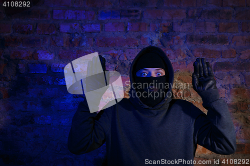 Image of Astonished thief with hands up