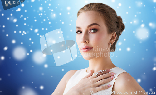 Image of woman in white dress with diamond jewelry and snow