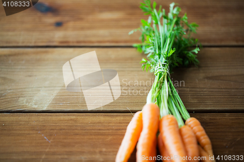 Image of close up of carrot bunch on wooden table