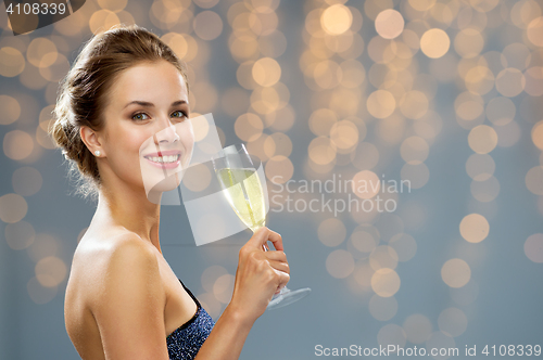 Image of smiling woman holding glass of champagne