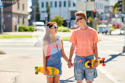 Image of teenage couple with skateboards on city street