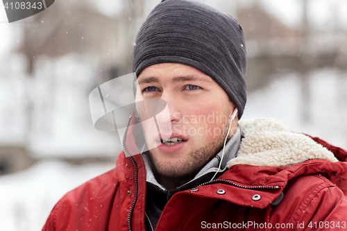 Image of man with earphones listening to music in winter