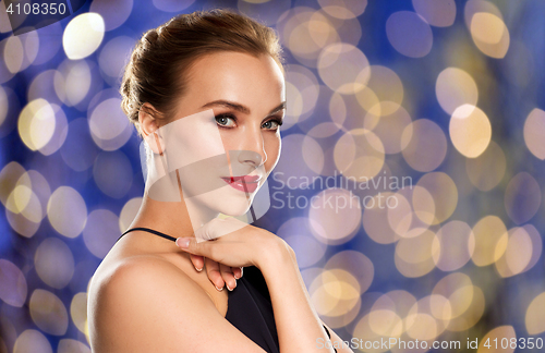 Image of beautiful woman in black over dark background