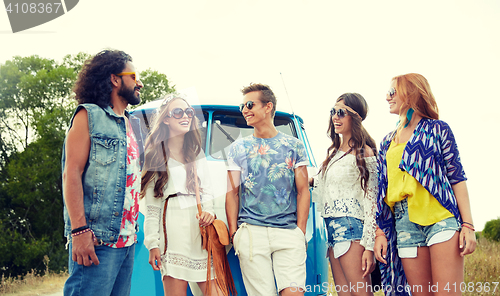 Image of smiling young hippie friends over minivan car