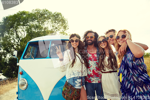 Image of hippie friends over minivan car showing peace sign