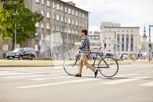 Image of young man with fixed gear bicycle on crosswalk