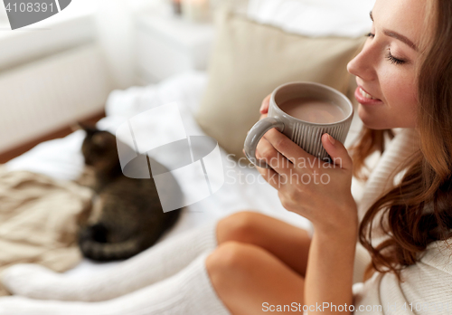 Image of close up of happy woman with cocoa cup at home