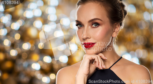 Image of beautiful woman in black over dark background