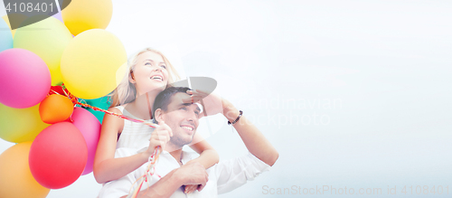 Image of couple with colorful balloons at seaside