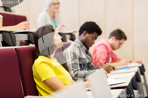 Image of group of students with notebooks in lecture hall