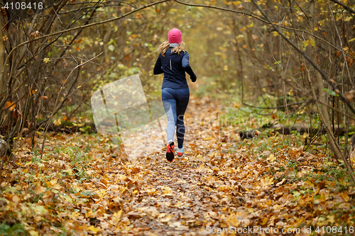 Image of Young woman jogging in morning