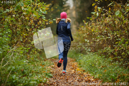 Image of Young blonde runs among trees