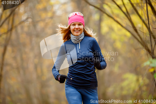 Image of Young woman jogging in morning