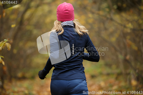 Image of Blonde woman jogging in morning