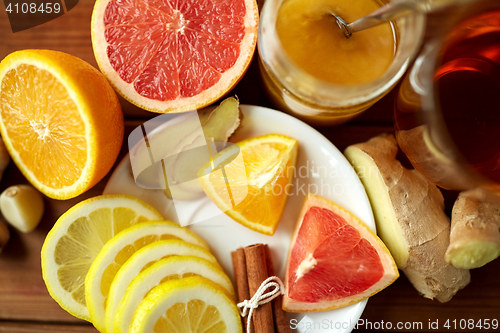 Image of ginger tea with honey, citrus and garlic on wood