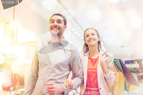 Image of happy young couple with shopping bags in mall