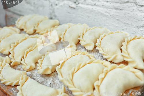 Image of Uncooked dumplings on the kitchen board 