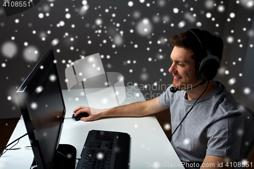 Image of man in headset playing computer video game at home