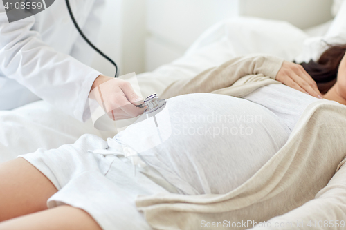 Image of doctor with stethoscope and pregnant woman