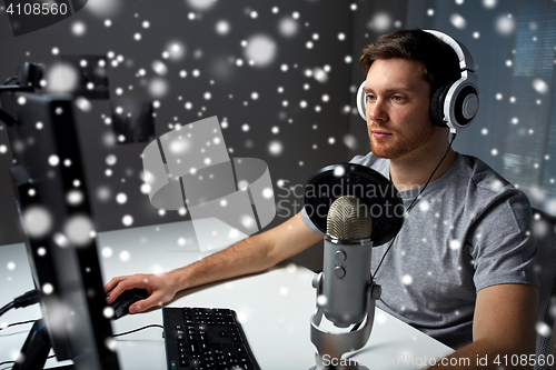 Image of man in headset playing computer video game at home