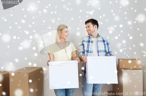 Image of smiling couple with big boxes moving to new home