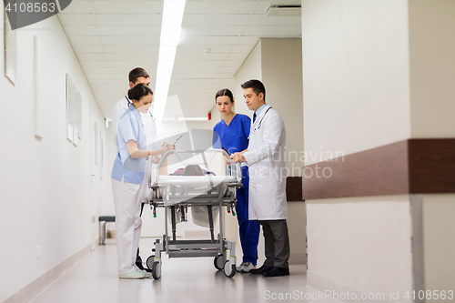 Image of medics with woman on hospital gurney at emergency