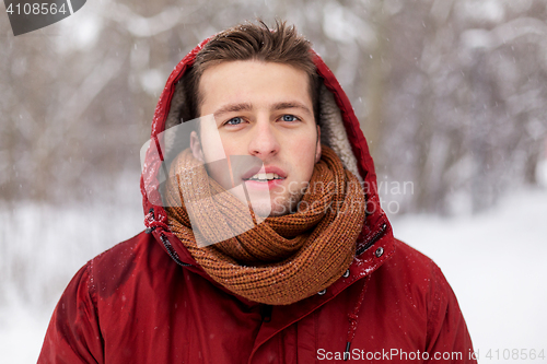 Image of happy man in winter jacket with hood outdoors