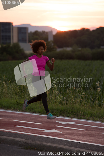 Image of a young African American woman jogging outdoors