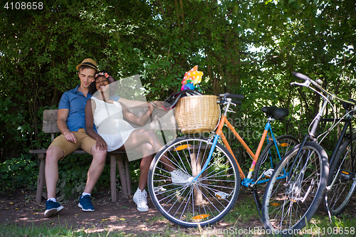 Image of Young multiethnic couple having a bike ride in nature