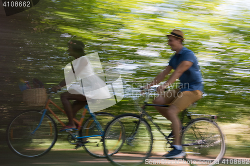 Image of Young multiethnic couple having a bike ride in nature