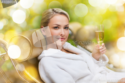 Image of beautiful young woman drinking champagne at spa