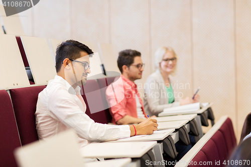 Image of group of students with notebooks in lecture hall