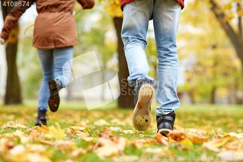 Image of young couple running in autumn park