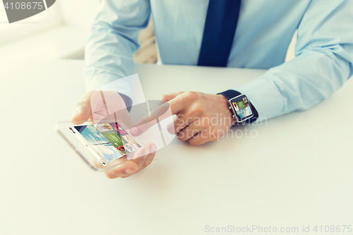 Image of close up of hands with smart phone and watch