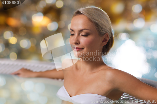 Image of happy womani sitting in jacuzzi at poolside