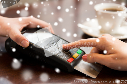 Image of close up of hands with credit card reader at cafe