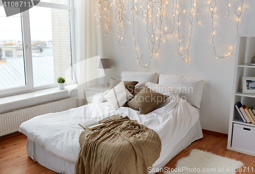 Image of bedroom with bed and christmas garland at home