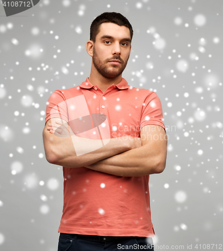Image of young man with crossed arms over snow