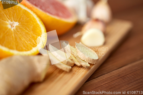 Image of ginger, garlic and orange on wooden board